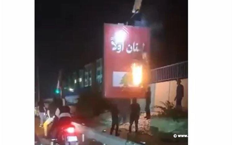 بالفيديو.. مناصرو حزب الله يحرقون لافتة "لبنان أولاً" على طريق المطار